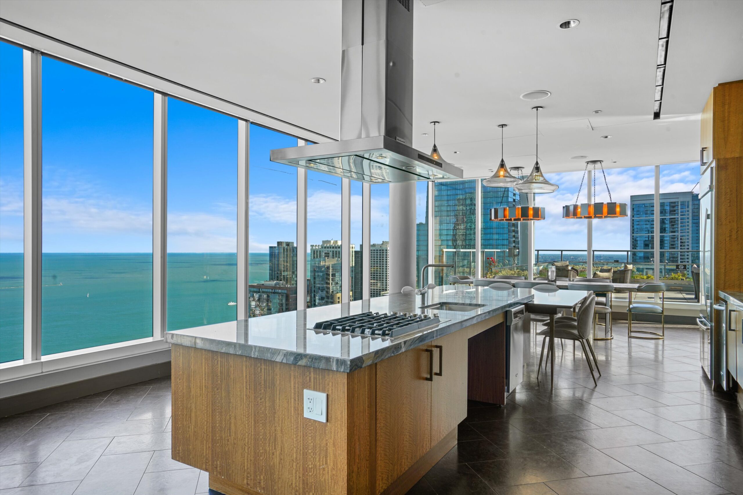 North Water Apartments Sky Lounge community kitchen with large island, modern chandeliers, and views of the city and lake